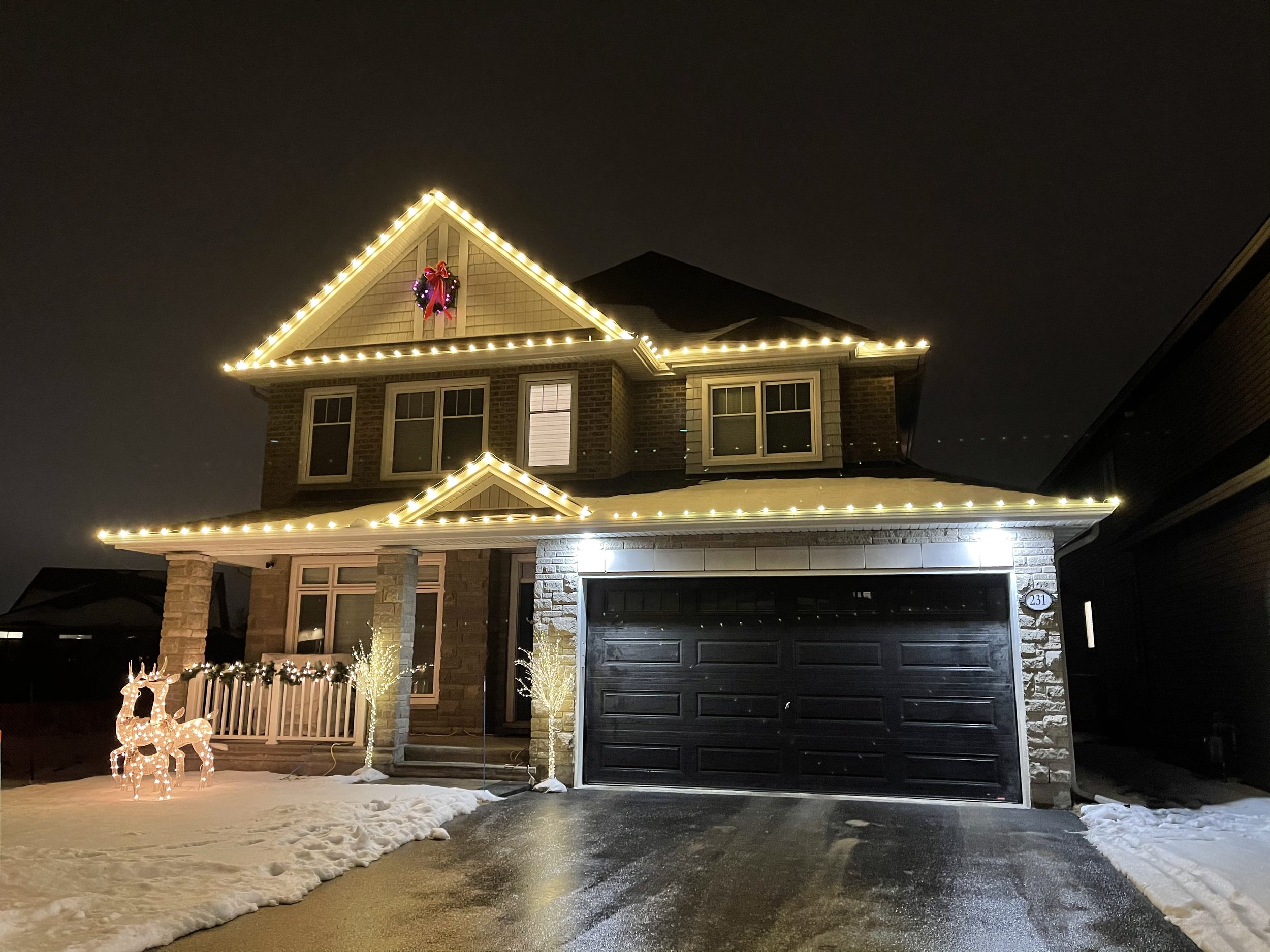 Two-storey Thunder Bay home outlined with professional Christmas lights at night