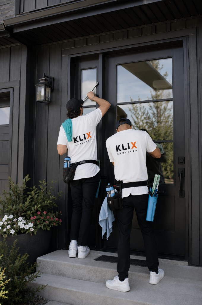 Klix crew cleaning black-framed entry glass on a Thunder Bay home