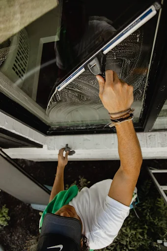 Close-up of a Klix squeegee pulling water off Thunder Bay window glass
