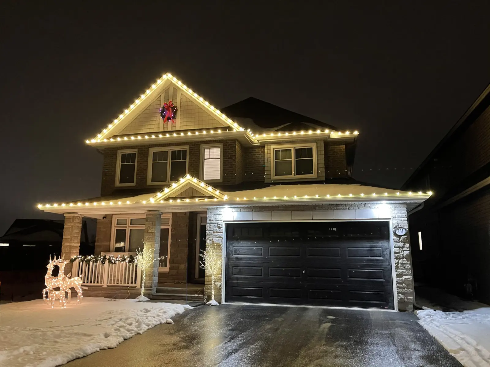 Two-storey Thunder Bay home outlined with professional Christmas lights at night